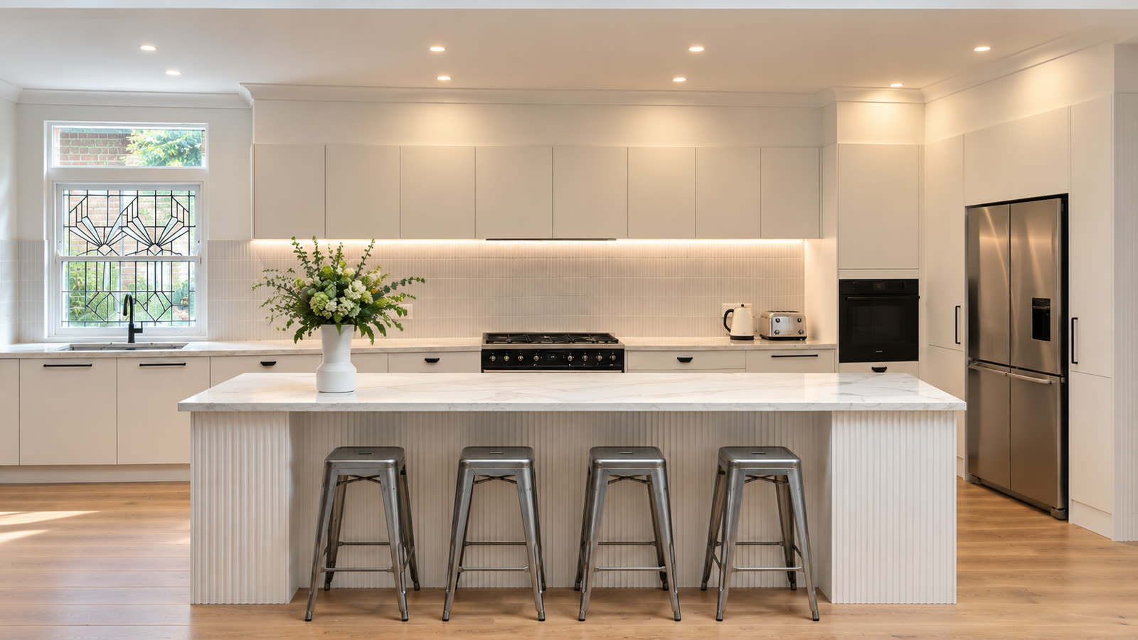 Modern kitchen with a fluted island, marble benchtops and oak floors
